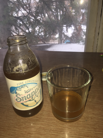 An open bottle of very old Snapple, some of it poured into a tumbler