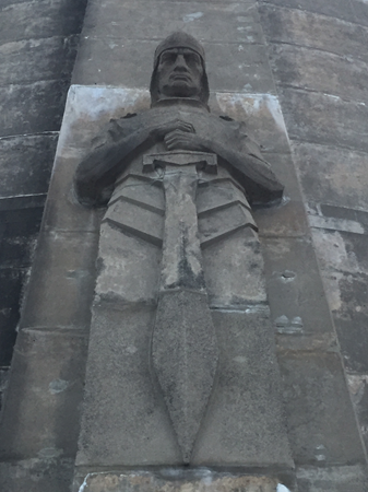 A somber stone figure with a sword